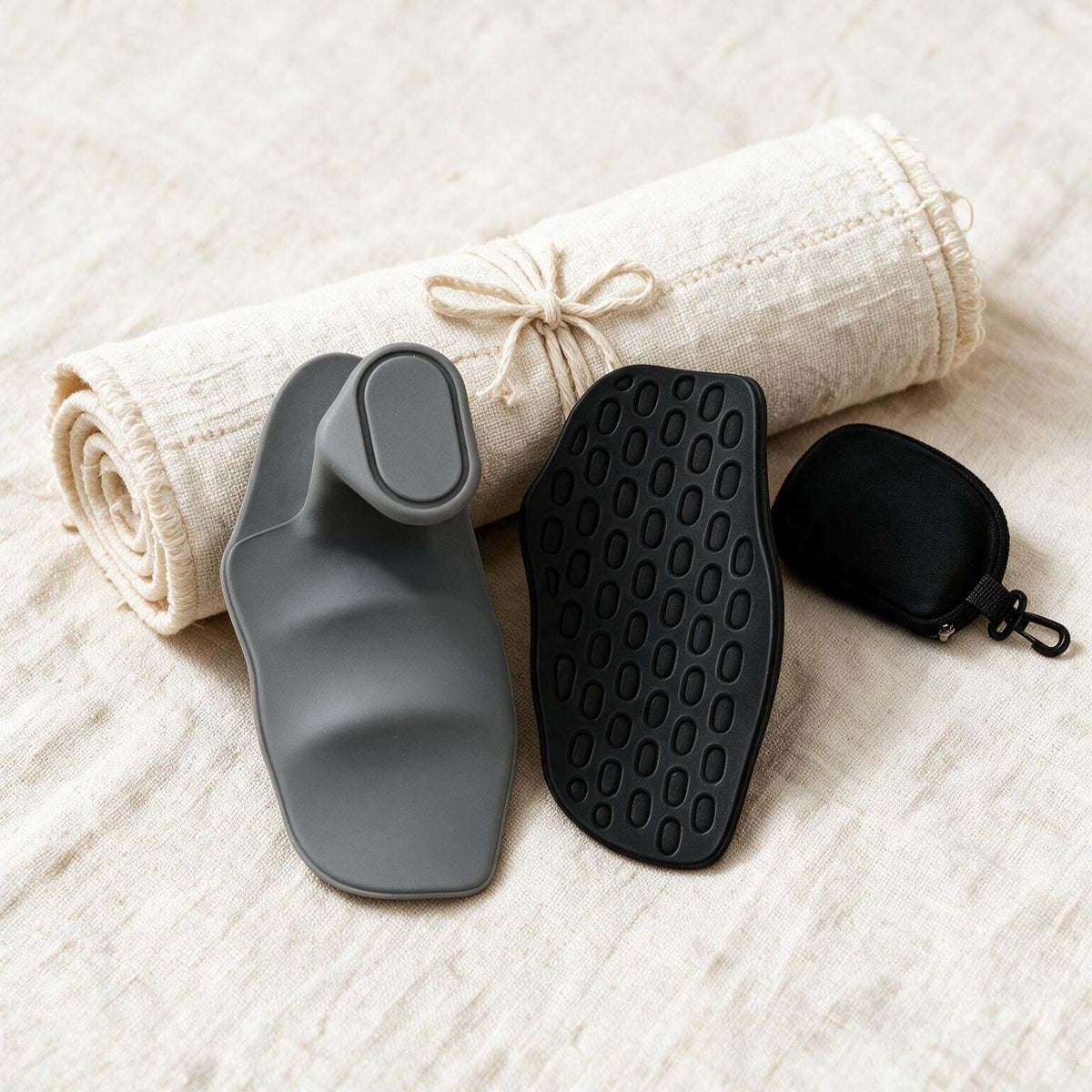 VOZA Kinetic Palm black and graphite pads flat-lay with carry pouch on cream linen